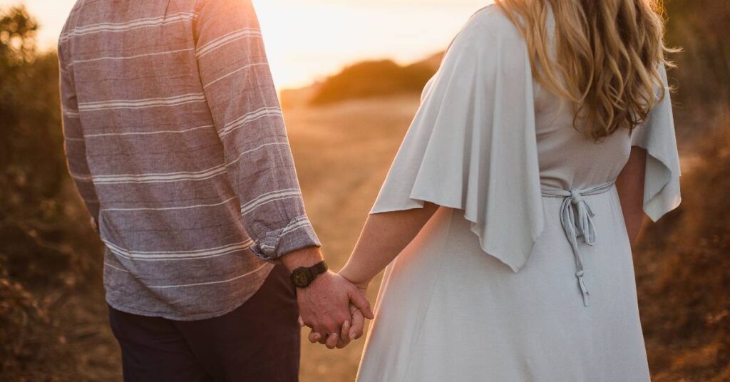 Christian couple holding hands while walking and discussing love map questions