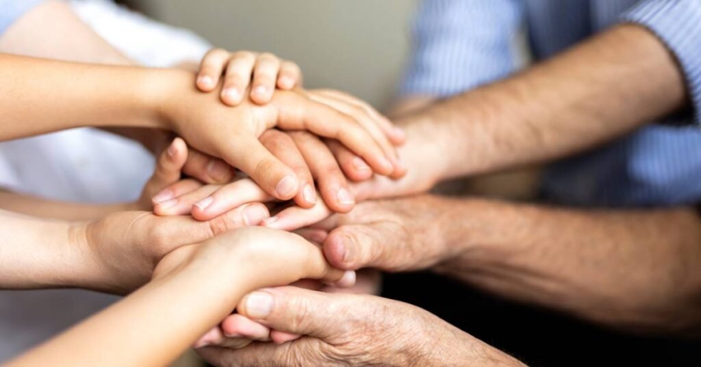 photo of a family stacking their hands for a family cheer as a fun family activity