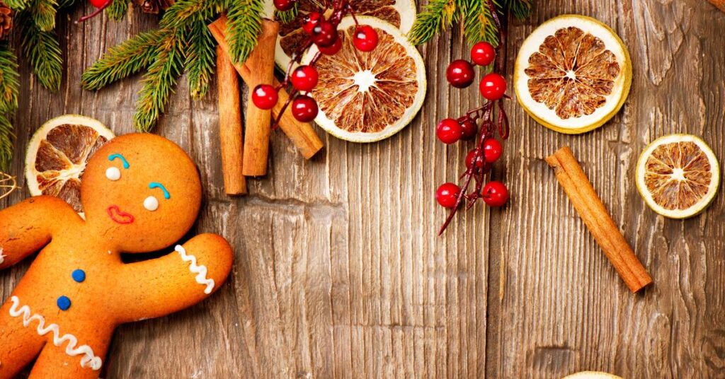 artsy picture for the Christmas holidays with a gingerbread man, holly, cinnamon sticks, and orange slices