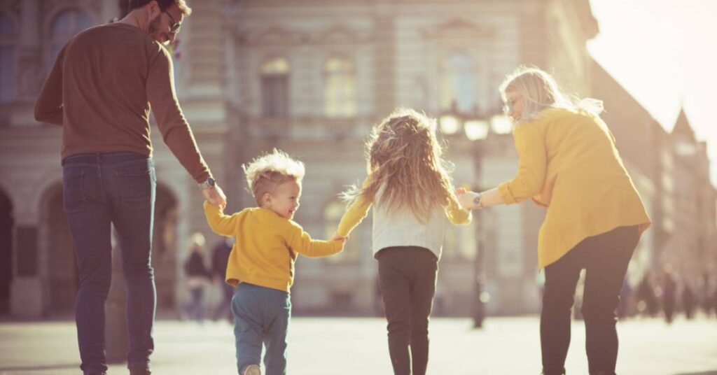 a Christian family with godly relationships walking through the streets holding hands and laughing together